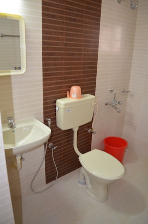 Un baño con inodoro, lavamanos y ducha.