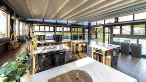 A modern kitchen with large windows, a marble countertop, and a high ceiling with skylights. - Benikea The Bliss Hotel (Incheon)
