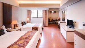 A hotel room with two beds, a desk, a TV, and a chair. - Waugh Den Hotel (Taichung)