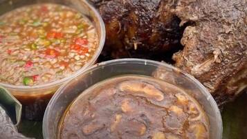 Primer plano de un plato con salsa oscura y pimientos verdes y rojos picados.