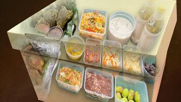A variety of food items in transparent containers, including what appears to be rice, soup, and possibly some meat dishes.