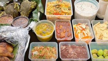 A variety of food items including grilled chicken, rice dishes, and different types of sauces.