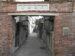 A narrow alleyway with brick walls and a sign above the entrance. - Smalleye Backpacker (Lukang)