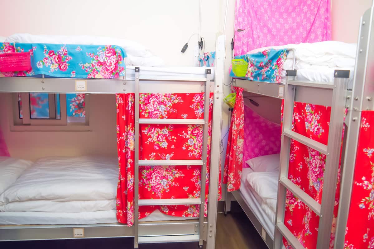 A bunk bed room with floral bedding and a ladder.