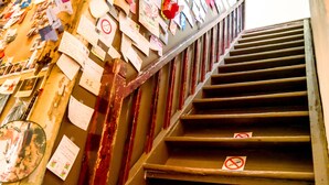 A staircase with multiple steps, some with red "no entry" signs, and walls covered with various papers and notes. - Smalleye Backpacker (Lukang)
