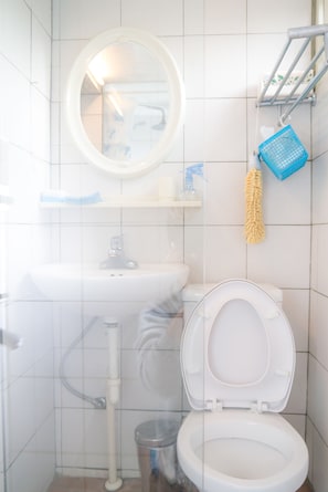 A bathroom with a toilet, sink, and mirror. - Smalleye Backpacker (Lukang)