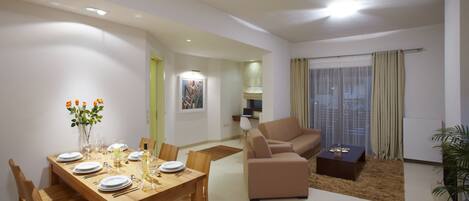 A modern living room with a dining area, a sofa, and a coffee table.