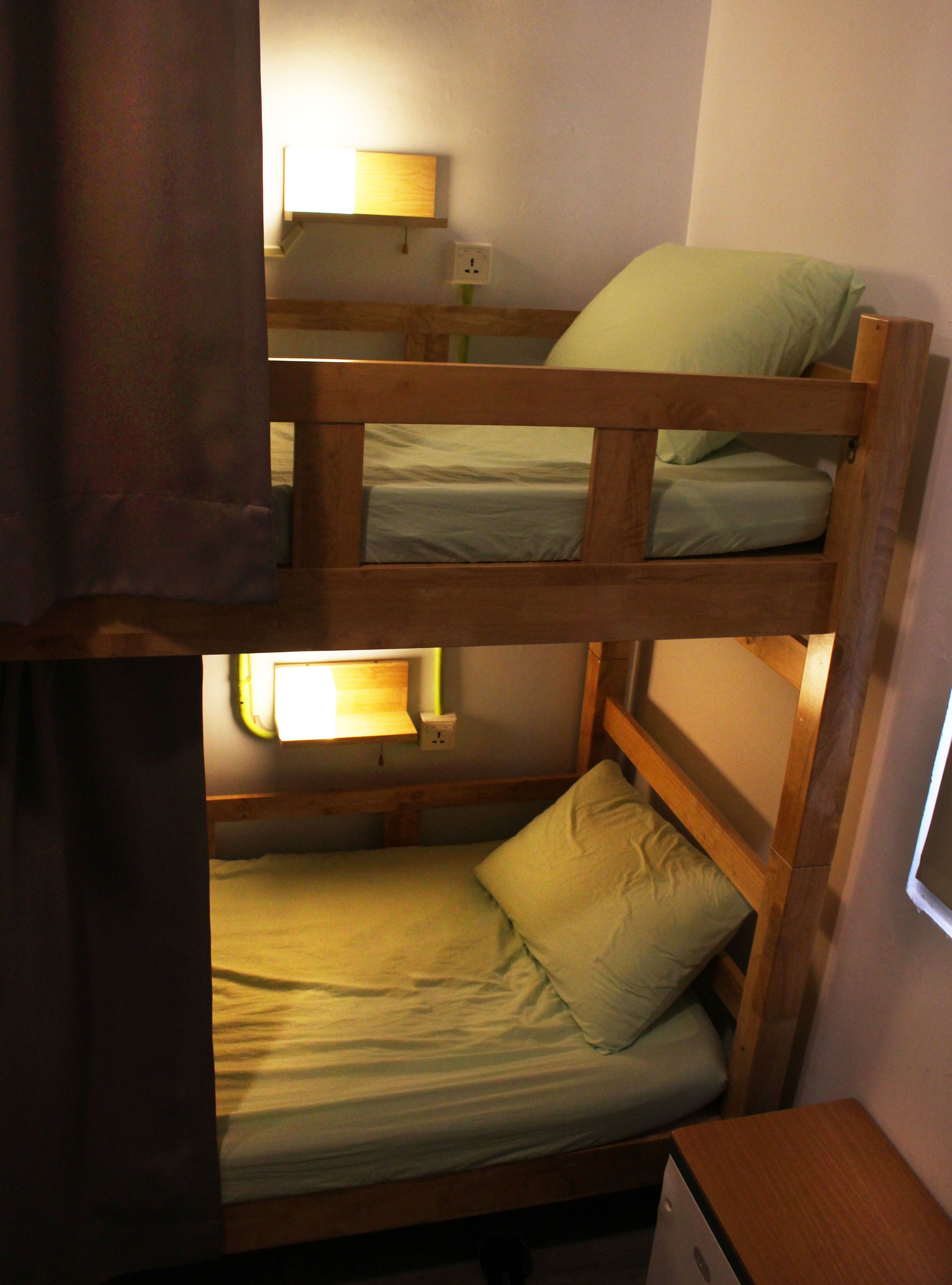 A bunk bed with a desk and a lamp.