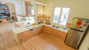 Una cocina moderna con armarios de madera, un refrigerador de acero inoxidable y un ventanal que proporciona luz natural.