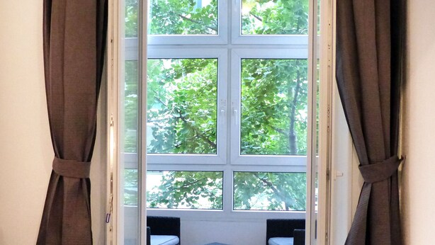 A room with a large window, two chairs, and a small table. - Pensión Donostiarra (San Sebastián)