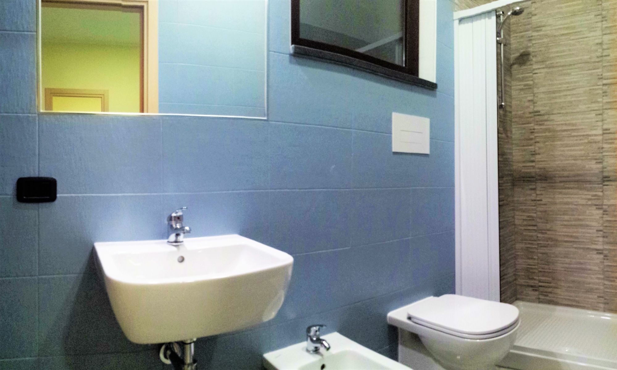 A bathroom with a white sink, a toilet, and a shower area.