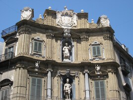 Un bâtiment historique doté de détails architecturaux raffinés, notamment des statues et des éléments décoratifs.