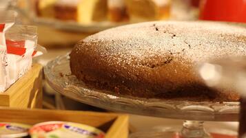 A cake on a glass stand with a dusting of powdered sugar on top.