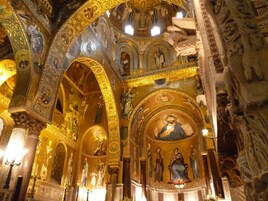 An interior with ornate golden arches and detailed mosaics.
