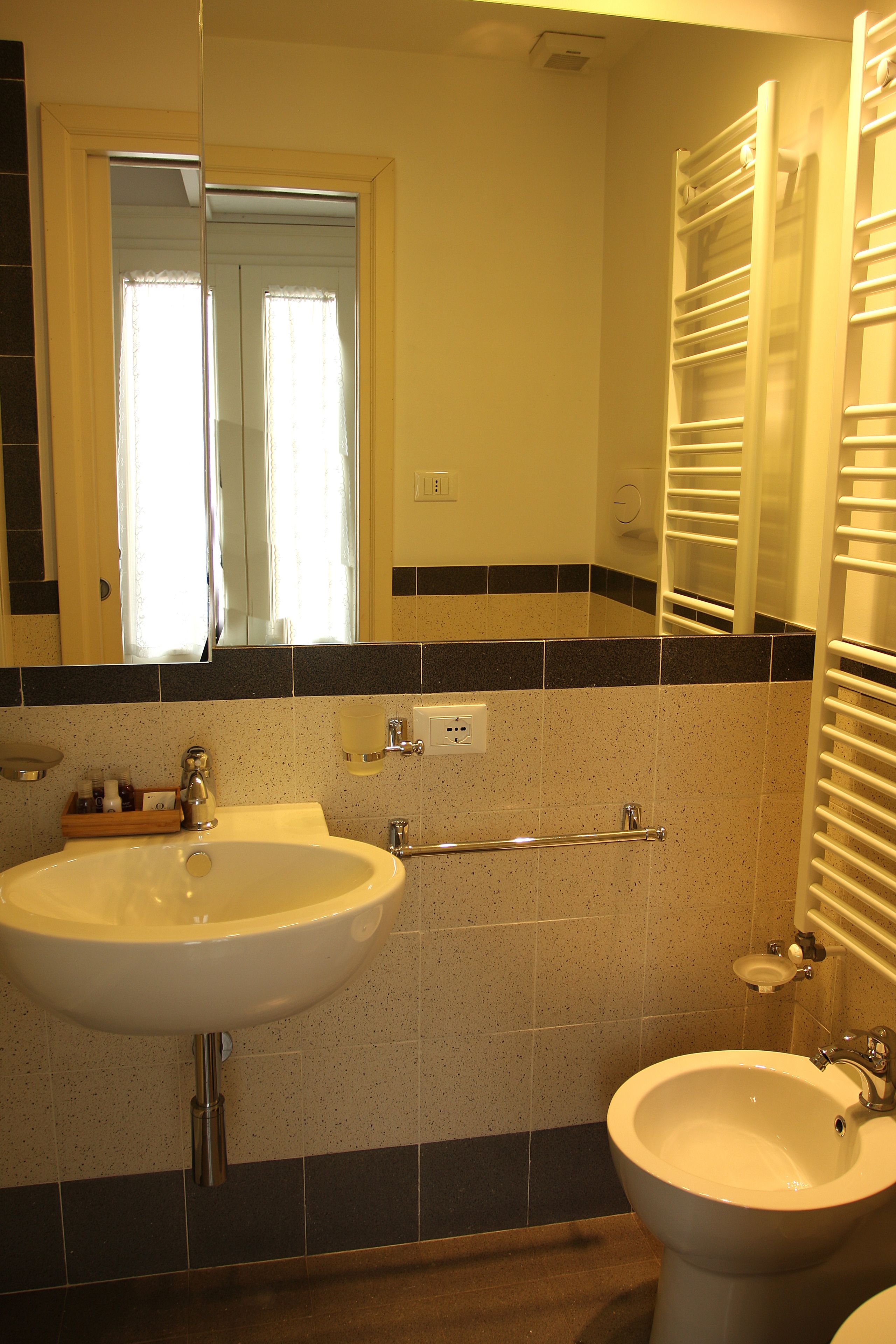 A bathroom with a sink, a mirror, a towel rack, and a door.