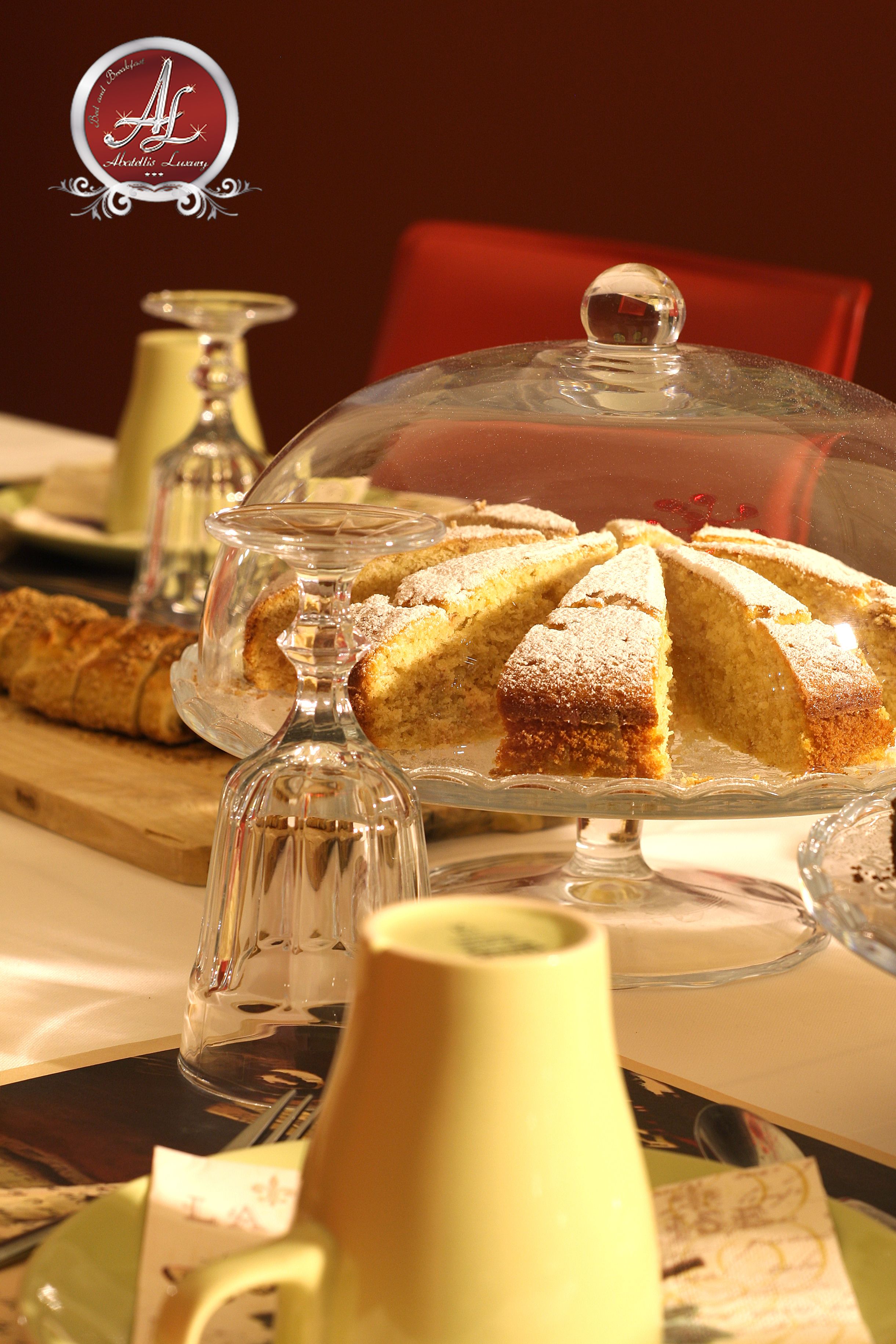 A cake on a glass stand with a dusting of powdered sugar.