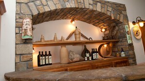 Una chimenea de piedra con un estante que muestra botellas y objetos decorativos.