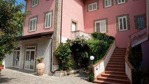 Un edificio rosa con varias ventanas y una escalera que lleva a un nivel superior.