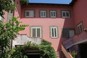 A pink building with multiple windows and a staircase.