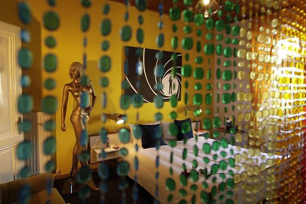 Une pièce comprenant un mannequin, un lit et un mur orné de motifs circulaires.