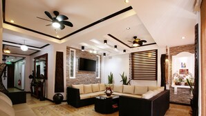 Un espacio habitable amplio con un sofá modular, una mesa de centro y un ventilador de techo.