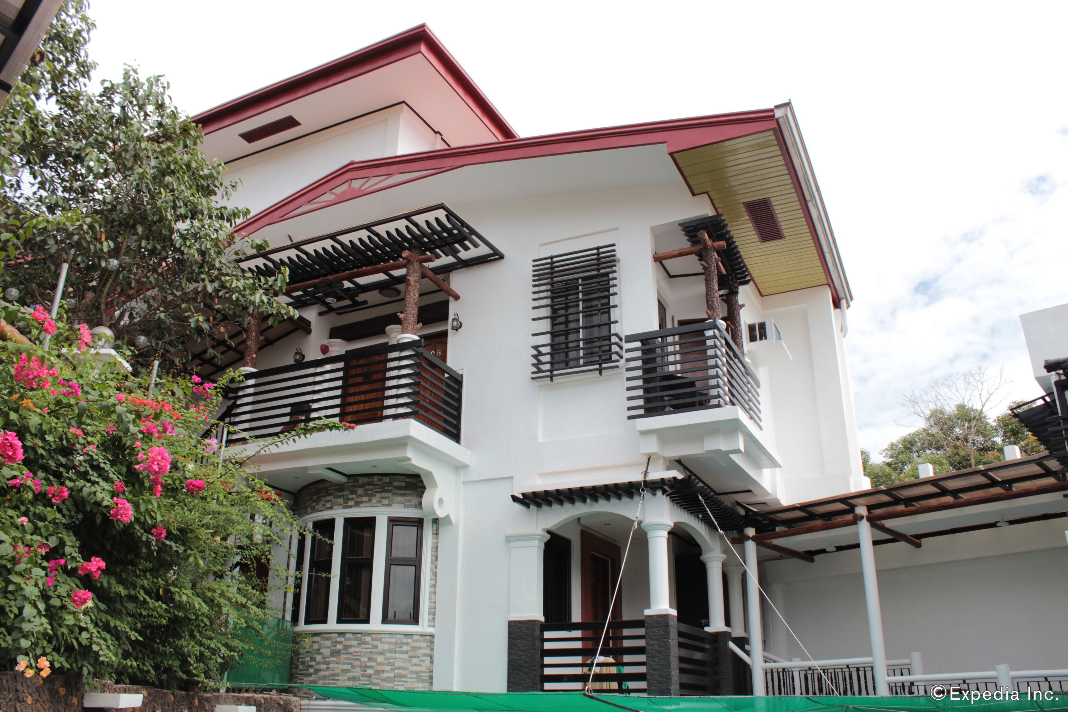 A two-story house with a balcony, a window, and a door.