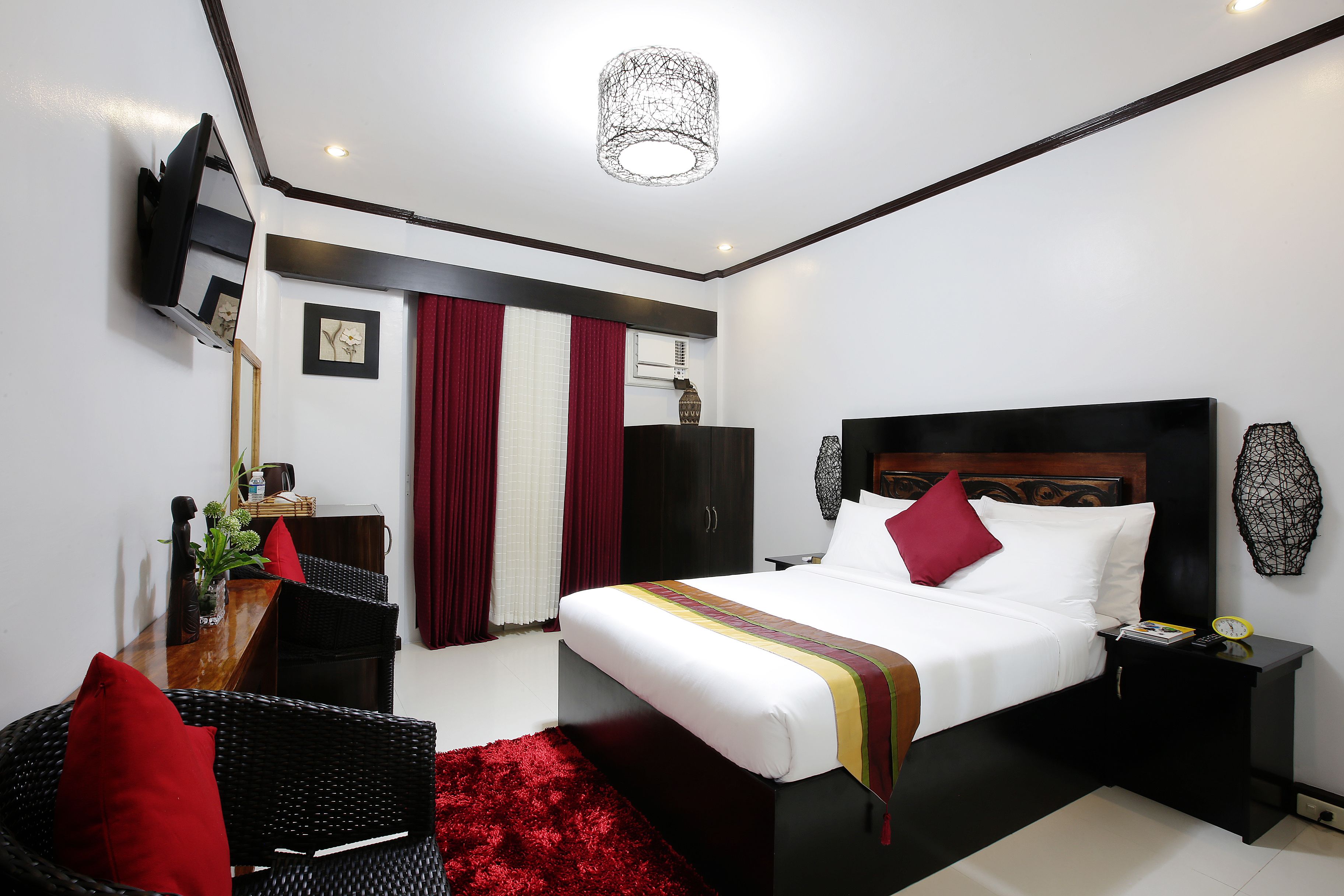A modern bedroom with a bed, bedside tables, a desk, and a chair.