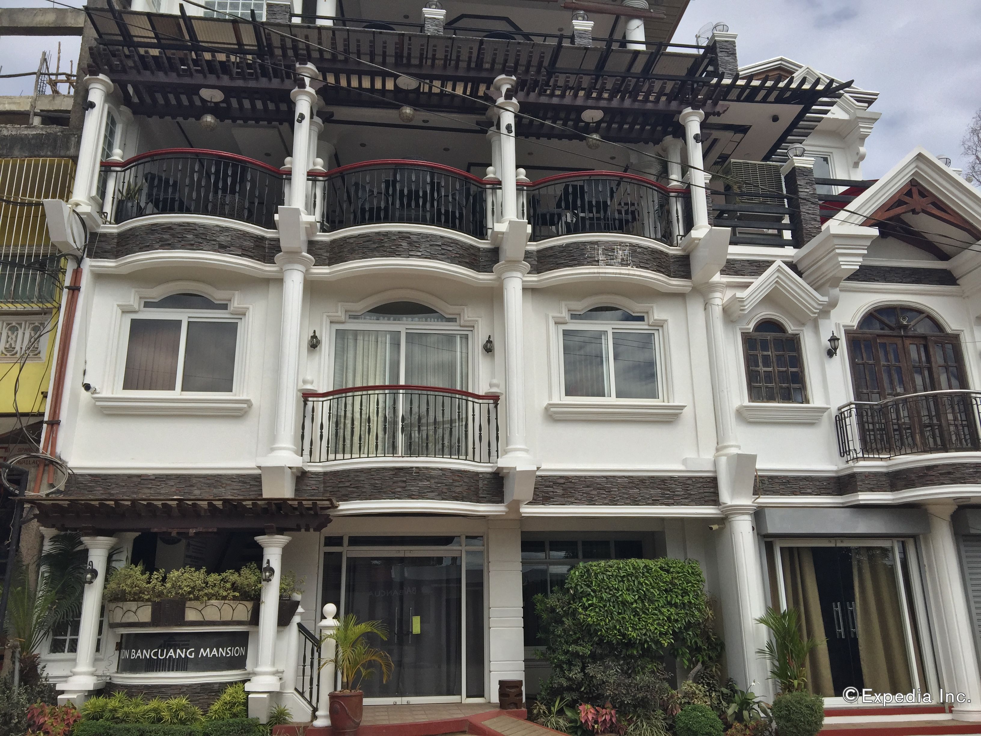 A multi-story building with balconies, a gated entrance, and a sign indicating it is a BANCUANG MANSION.