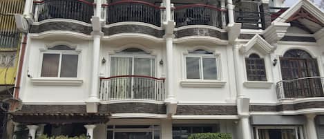 A multi-story building with balconies, a gated entrance, and a sign indicating it is a BANCUANG MANSION.
