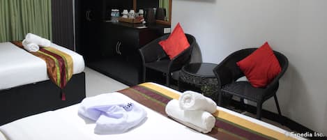 Una habitación de hotel con cama, escritorio, silla, mesita y televisor.