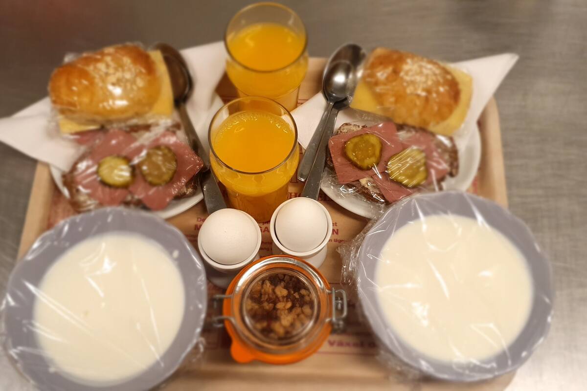 A tray with breakfast items including eggs, bread, and juice.