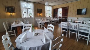 A dining area with round tables, white chairs, and candle centerpieces. - Sonfjällsgården Wärdshus & Hotell (Hede)