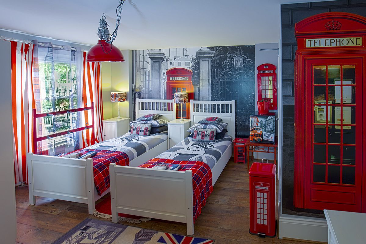 Une chambre avec deux lits, un téléphone public rouge et une fresque murale représentant un téléphone public rouge.