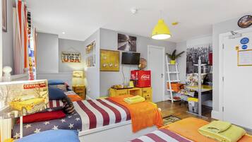 A hotel room with two beds, a TV, a bookshelf, and a desk with a Coca-Cola cooler.