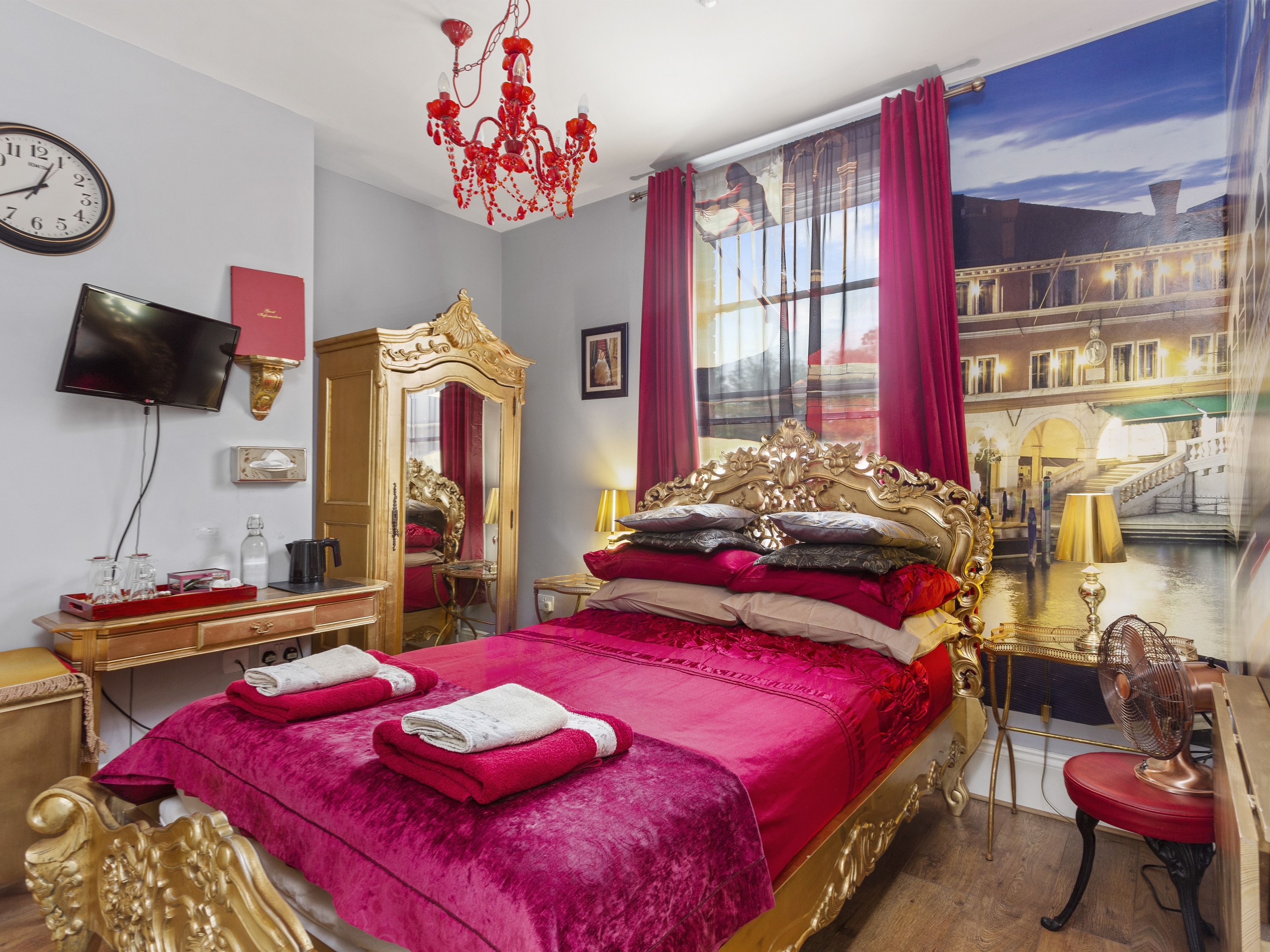 Una lujosa habitación de hotel con una cama grande, un espejo, un televisor y vistas a un canal.