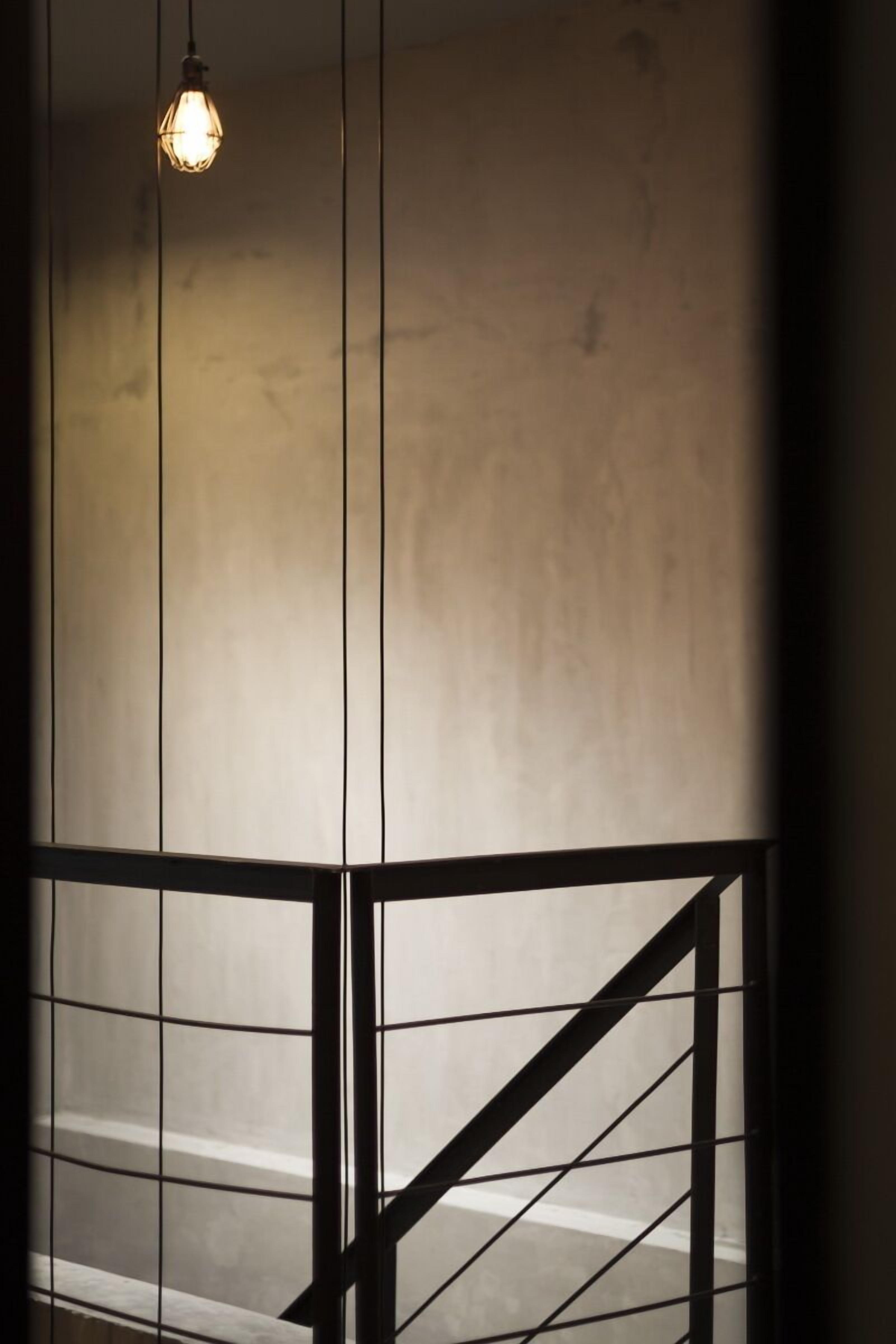 A staircase with a metal railing and a hanging light fixture.