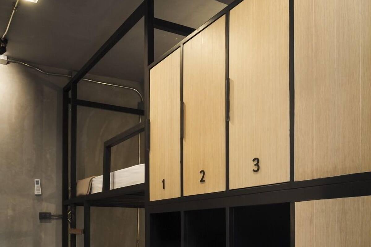 A bunk bed room with numbered lockers and a ladder.