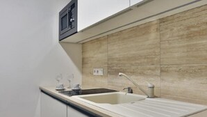 Una cocina moderna con microondas integrado, un lavamanos y una encimera.