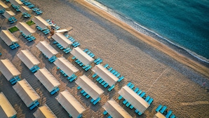 An aerial view of a beach with rows of tents and lounge chairs arranged along the shoreline. - Crystal Prestige Pearl Collection - All inclusive (Kemer)