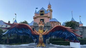 A castle-like structure with a sign reading 'Magic Castle' and a large winged statue in front.