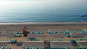 Ein Strand mit Liegestuhlreihen und einem Rettungsturm.