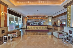 Eine Bar mit einer Marmor-Theke, Sitzgelegenheiten und Blick durch eine Glaswand.