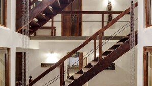 A multi-level wooden staircase with a stone base and metal railings. - Niyati - Boutique Stay (Kochi)