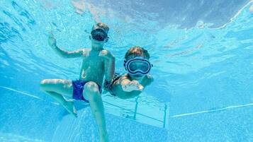 An underwater view of a swimming pool with clear water and a visible pool ladder.