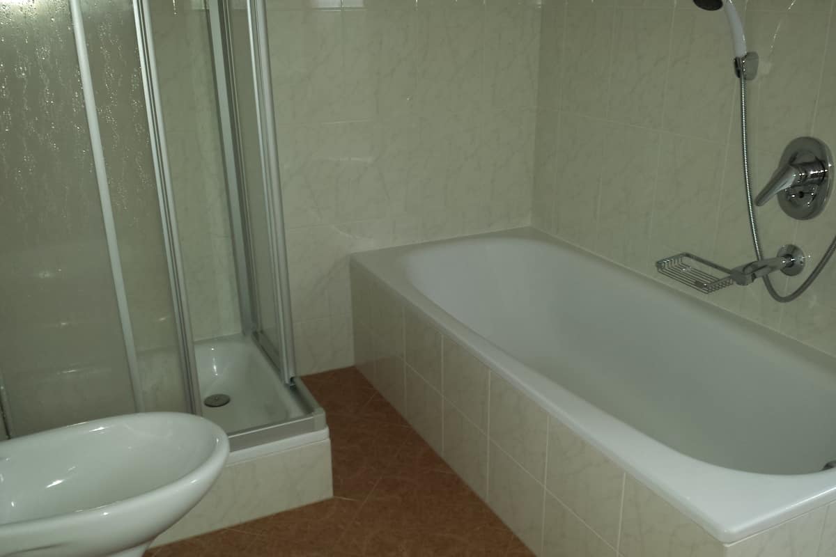 A bathroom with a bathtub, toilet, and shower.
