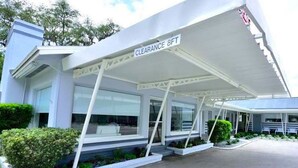A modern building with a covered entrance and a sign indicating a clearance of 8 feet. - Sun Plaza Motel (Silver Springs)
