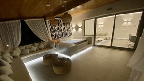 Un interior moderno con una zona de estar, un ventanal grande y una chimenea empotrada.
