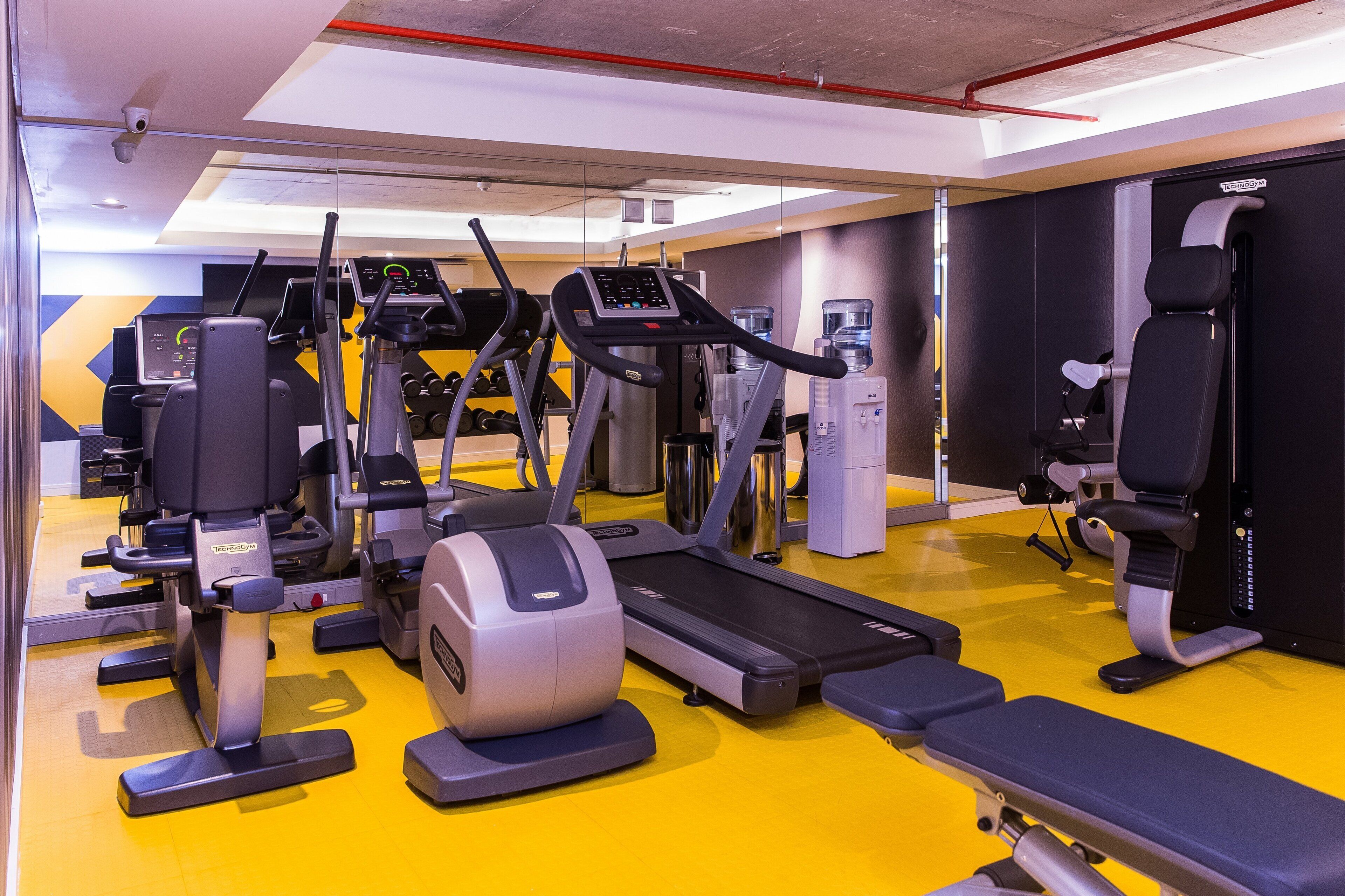 Ein Fitnessstudio mit Laufbändern, Crosstrainern und Kraftgeräten.