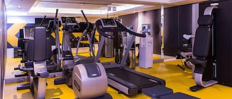 Ein Fitnessstudio mit Laufbändern, Crosstrainern und Kraftgeräten.