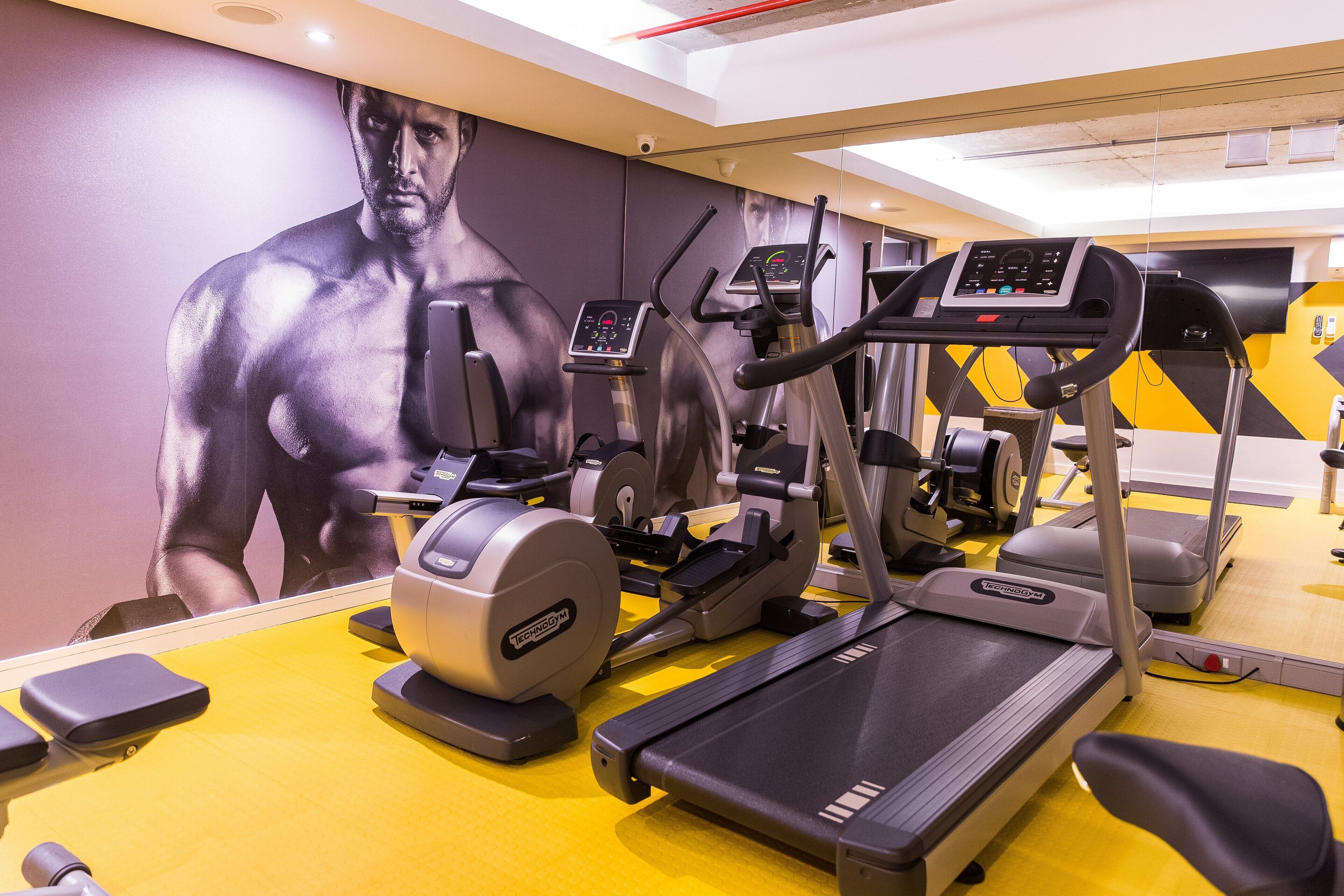 A gym with treadmills, elliptical machines, and weight equipment.